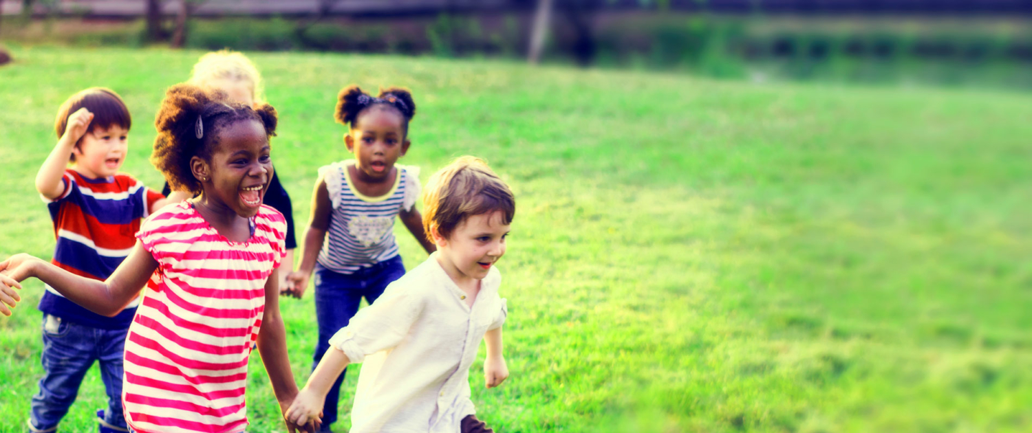 children holding hands running on grass